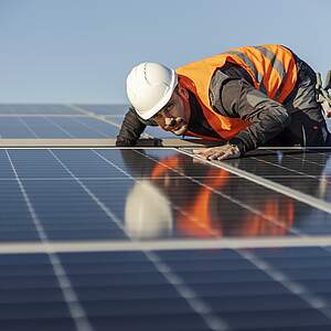 Arbeiter kontrolliert Solaranlage auf dem Dach