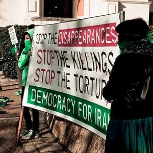 Frauen halten ein Banner gegen staatliche Folter und Mord im Iran