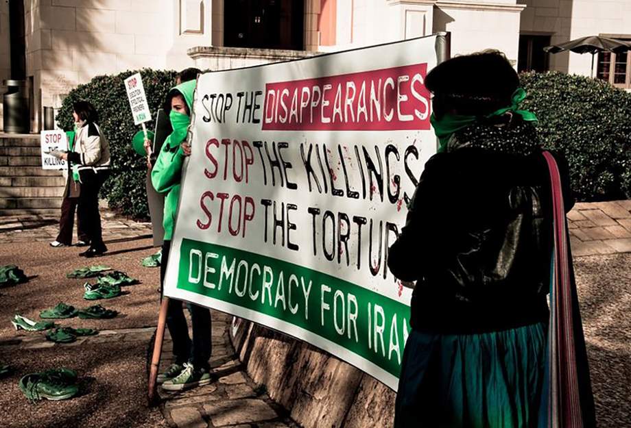 Frauen halten ein Banner gegen staatliche Folter und Mord im Iran