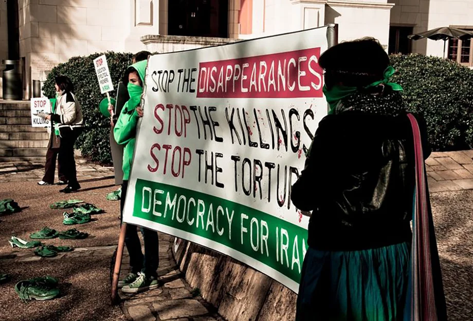 Frauen halten ein Banner gegen staatliche Folter und Mord im Iran
