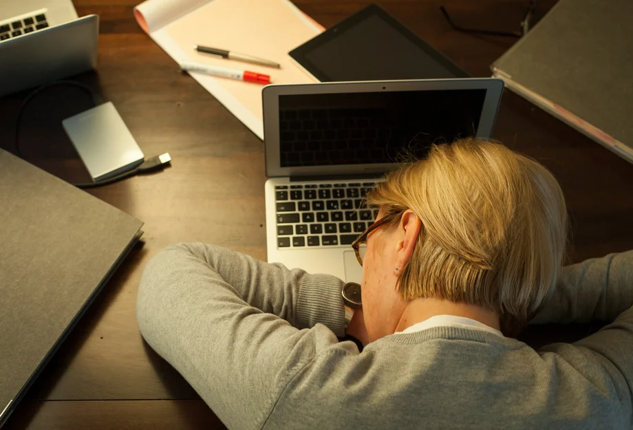 Total übermüdet Frau schläft auf Laptop ein