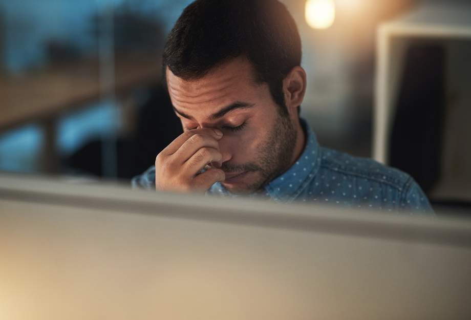 Erschöpfter Mann am Abend im Büro