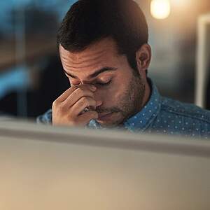 Erschöpfter Mann am Abend im Büro