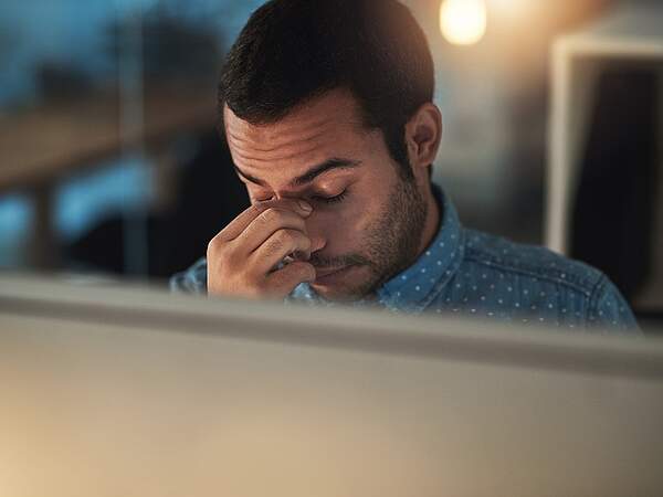 Erschöpfter Mann am Abend im Büro