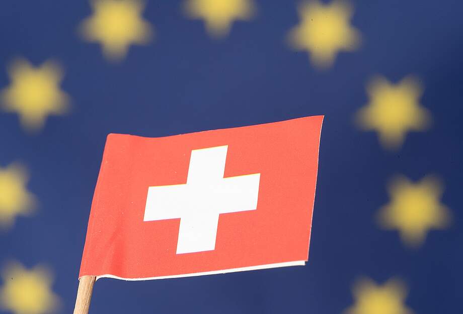 Schweizerfahne vor EU-Fahne