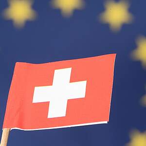 Schweizerfahne vor EU-Fahne