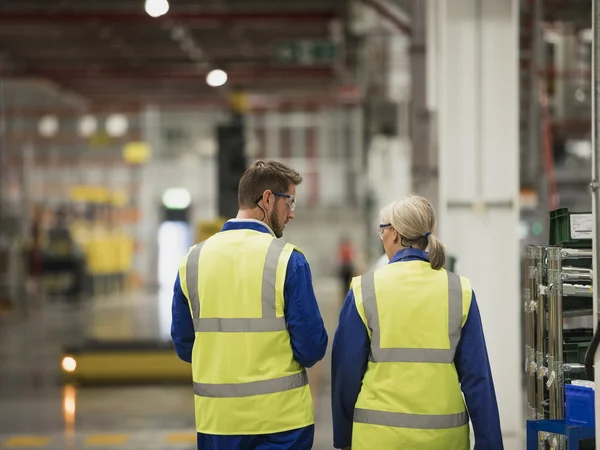 Mann und Frau in einer Fabrik