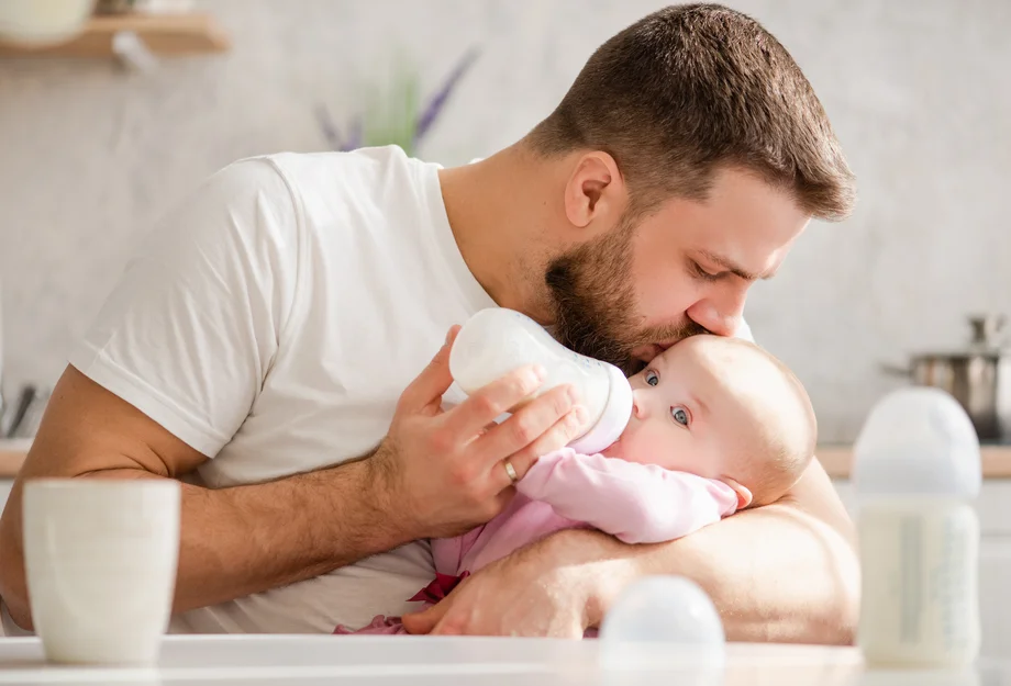 Stillender Vater Ein Vater gibt seinem Kind Milch