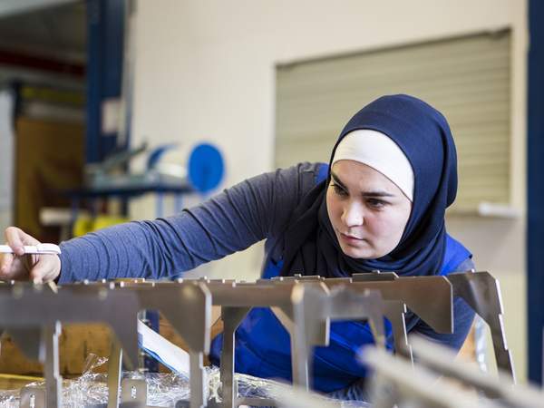 Auszubildende mit Kopftuch macht Qualitätskontrolle