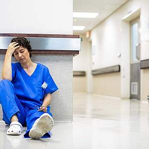 Pflegerin erschöpft am Boden