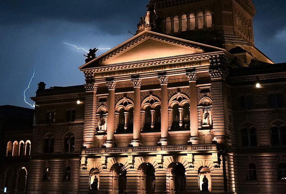 Bundeshaus bei Nacht, im Hintergrund Blitze