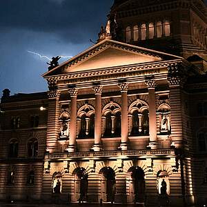 Bundeshaus bei Nacht, im Hintergrund Blitze