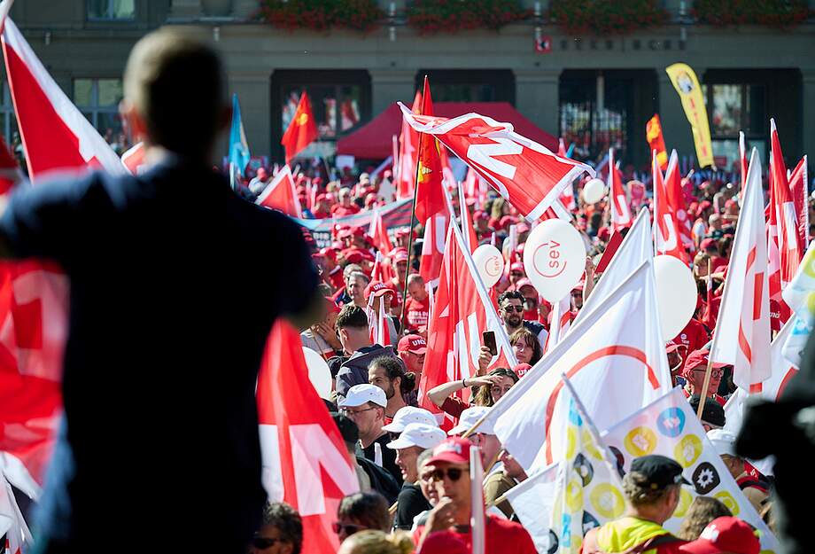 Demonstranten schwingen Gewerkschaftsfahnen