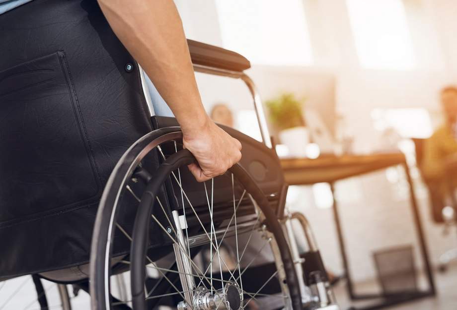 Person im Rollstuhl am Arbeitsplatz