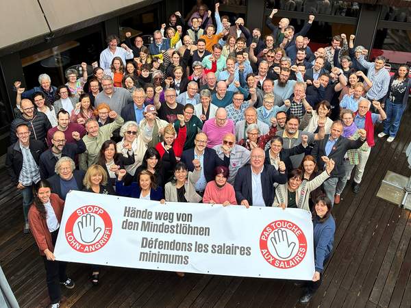 Gewerkschafterinnen und Gewerkschafter halten ein Transparent gegen den Angriff auf den Mindestlohn