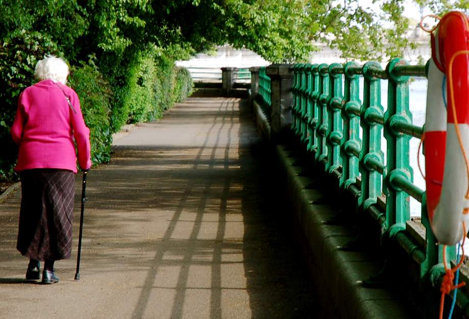 ältere Frau beim Spaziergang mit Rollator