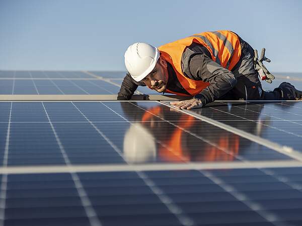 Arbeiter kontrolliert Solaranlage auf dem Dach
