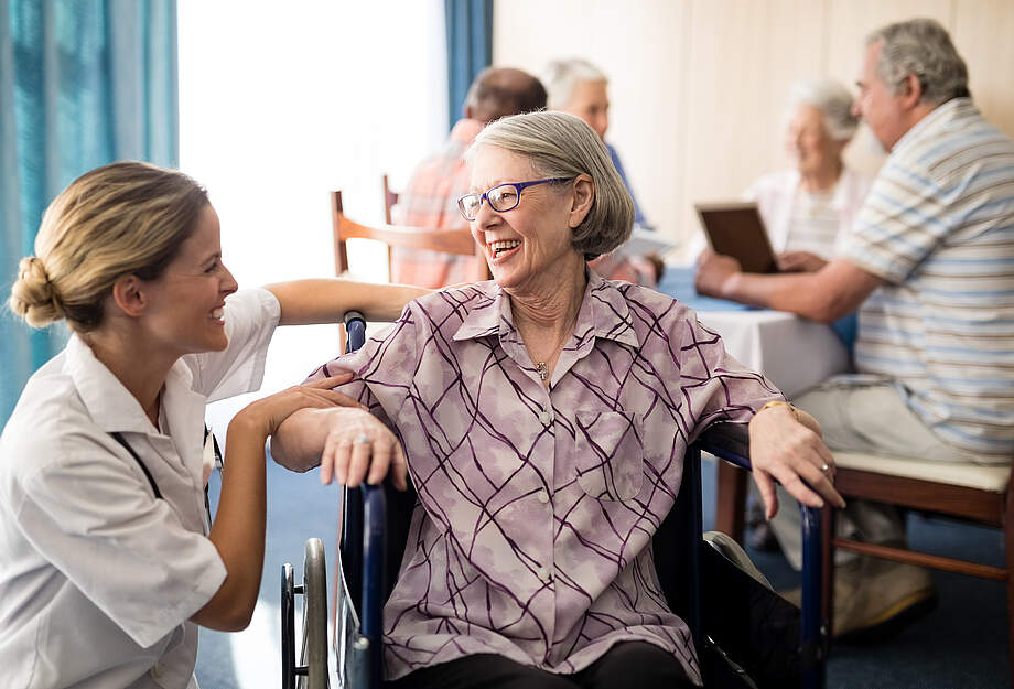 Pflegerin mit Seniorin im Heim